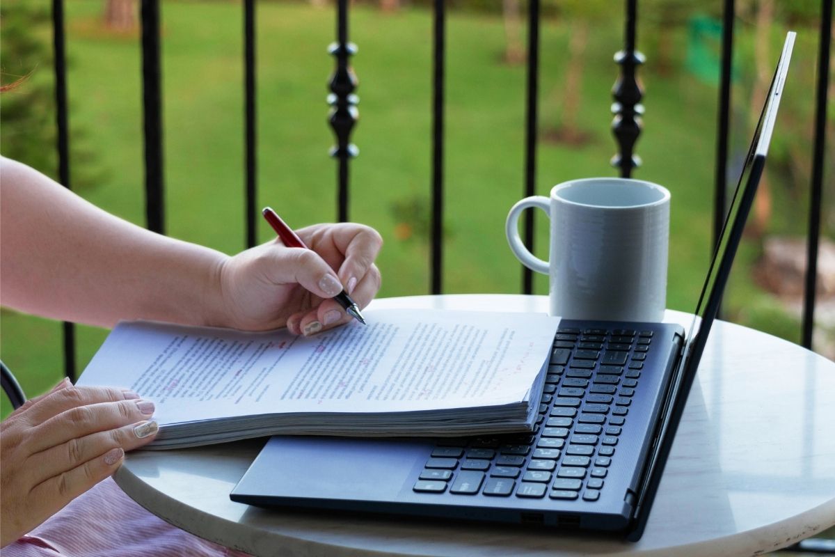 The picture of a woman's hand reading the papers as a proofreader.