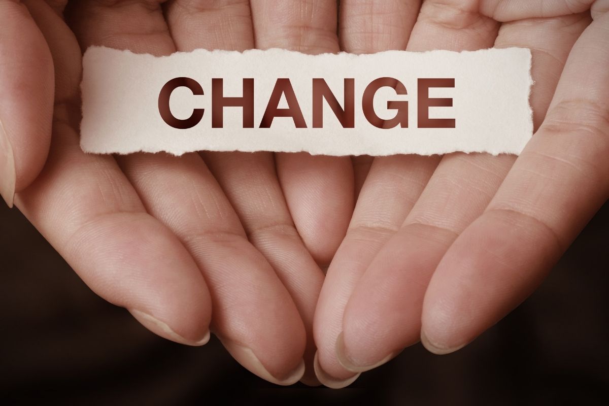 The photo tells about a girl's hand holding a piece of paper indicating that avoiding change vs seeking growth is a clear sign of who will move forward financially.