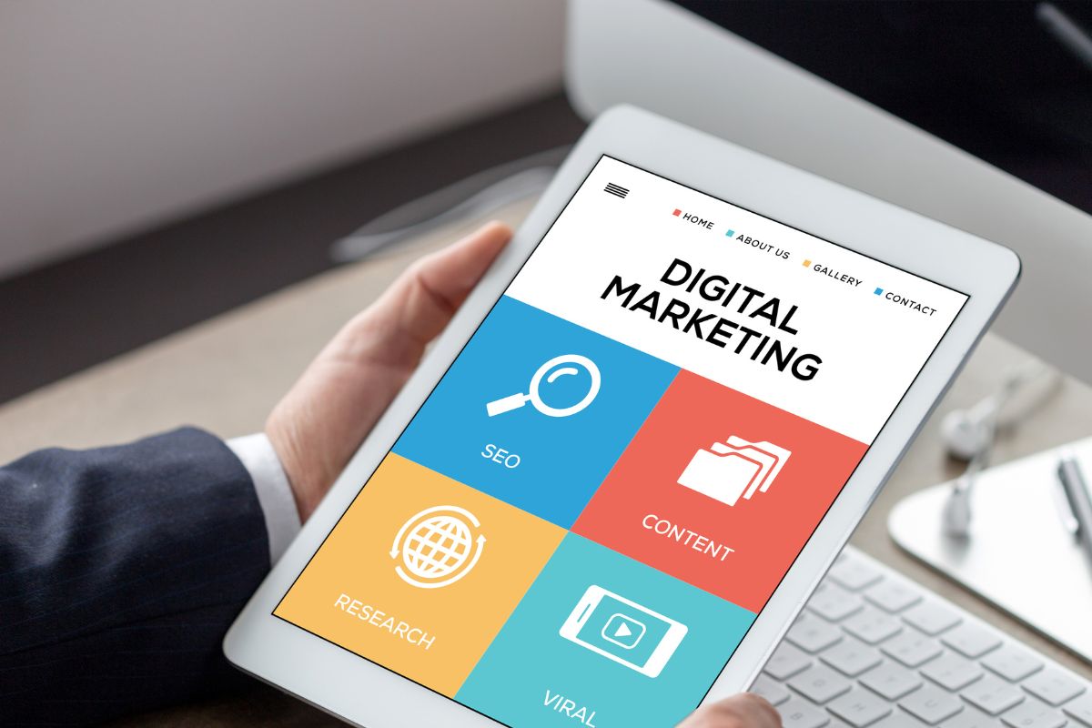 The image shows a man's hand using a tablet device with digital marketing wording.