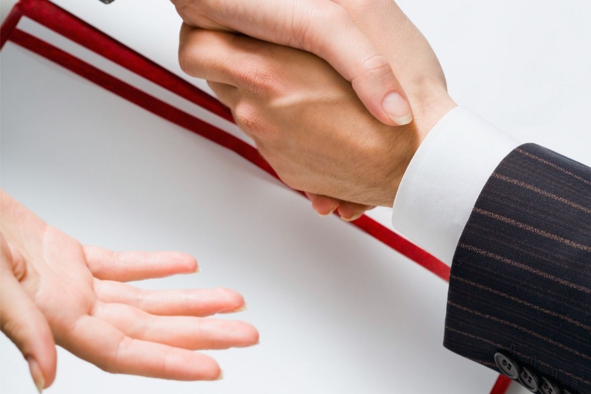 The image shows two hands shaking for dealing with sales and negotiation.