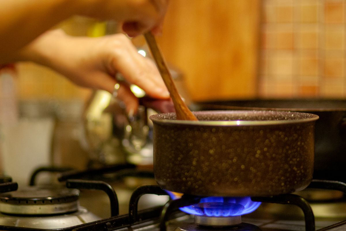 The photo shows a hand stirring the pan