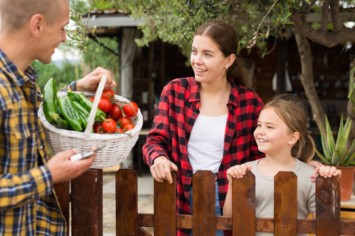 The image is about a girl and a man holding a basket with vegetables which refers to swapping goods with neighbors to help people live better without always spending money.