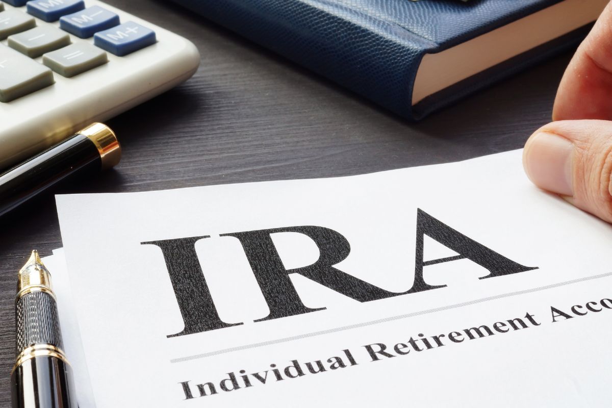 The photo of a man's hand holding a paper with IRA wordings.