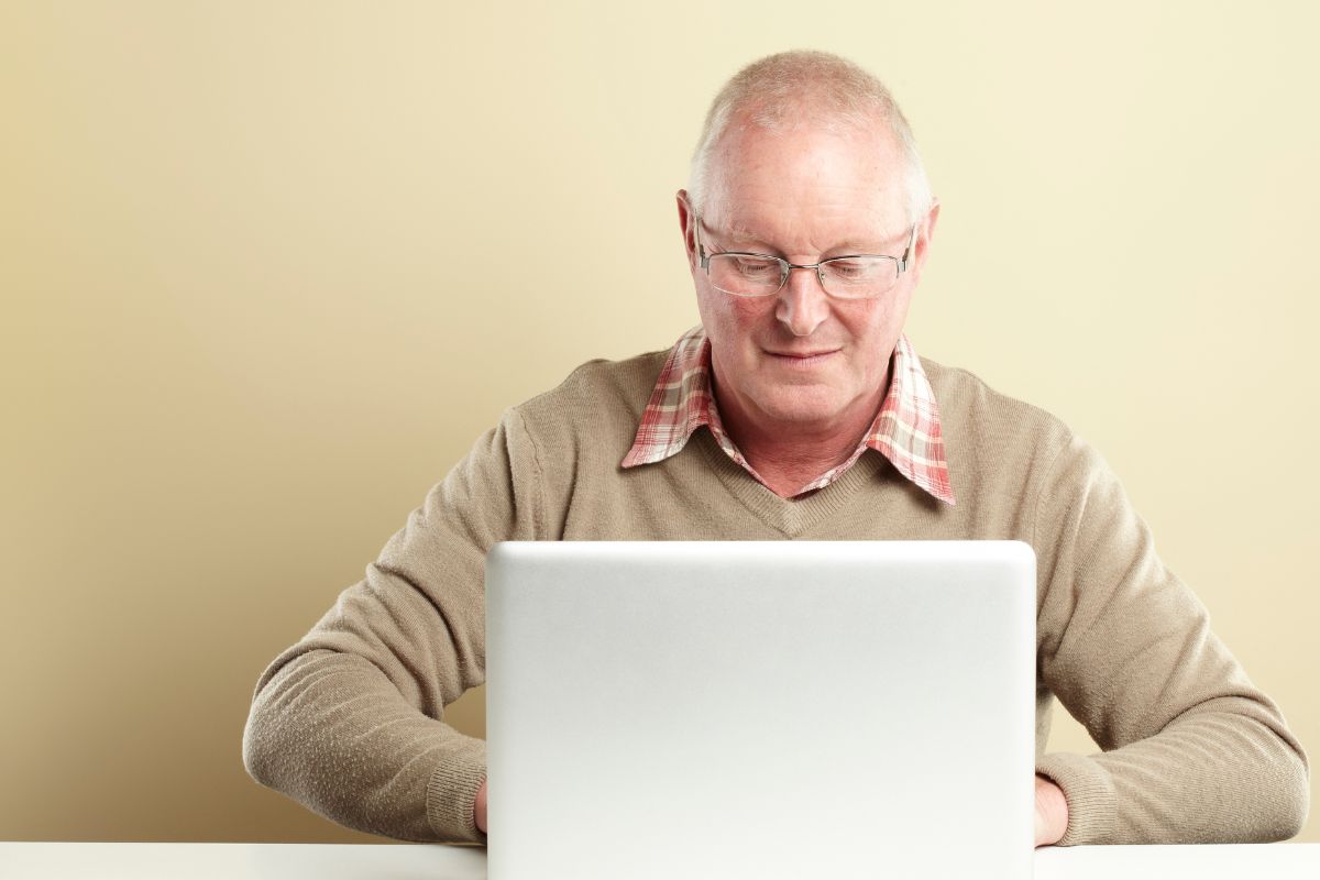 The picture of a senior man working on his laptop.