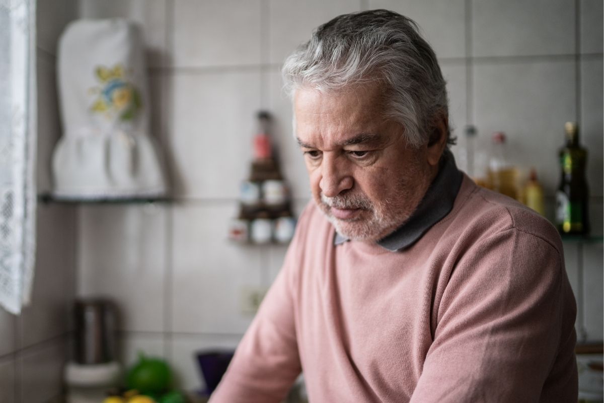 The image shows a guilty senior man thinking deeply.