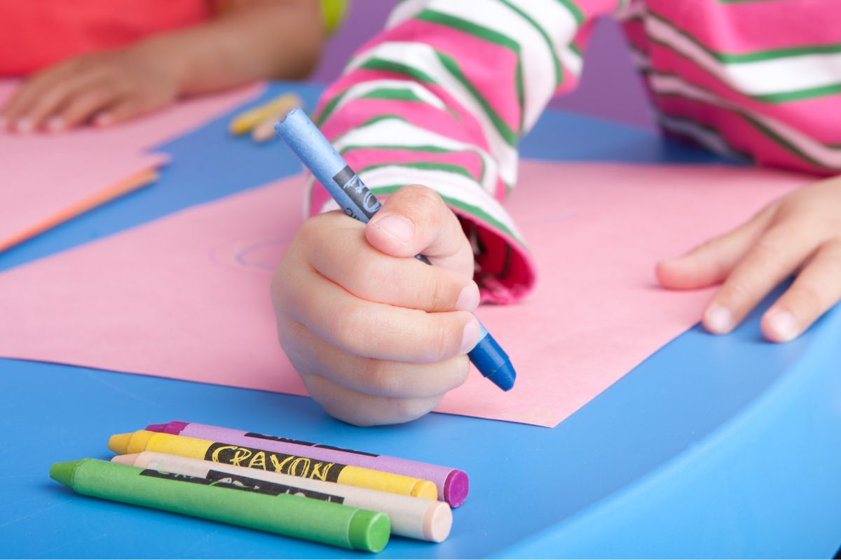 The photo shows kids coloring the papers with crayons.