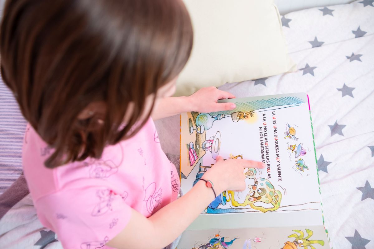 The picture of a girl reading a storybook.