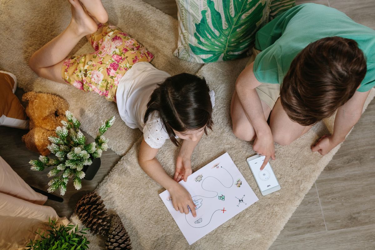 The picture of kids analyzing the map and using a phone.