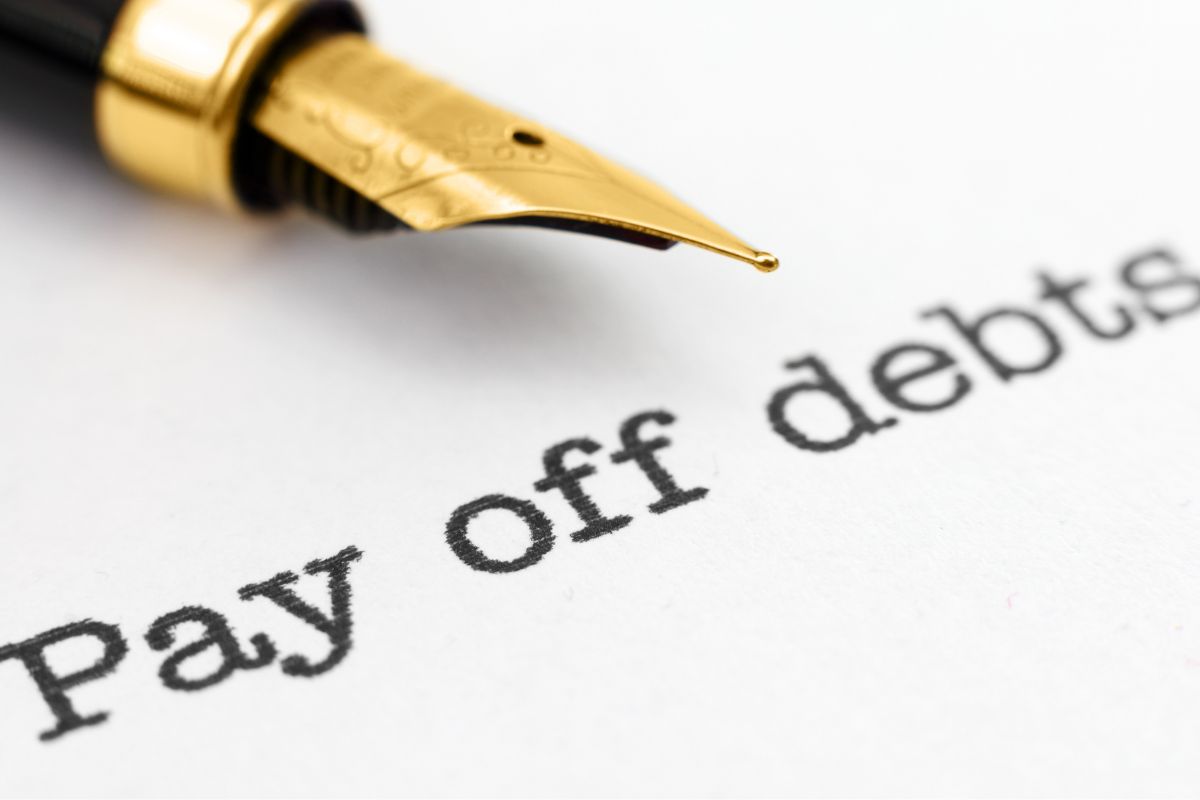 The photo shows a pen and Pay off debts wordings.
