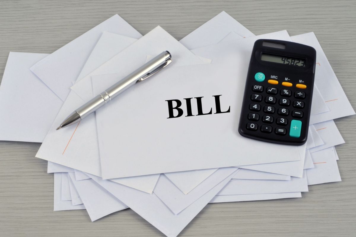 The photo of a calculator and envelopes with negotiated bills.