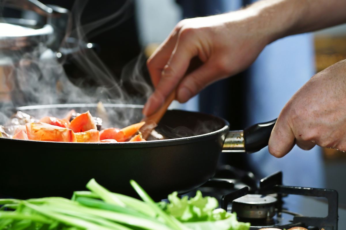 The image shows a woman cooking in bulk.