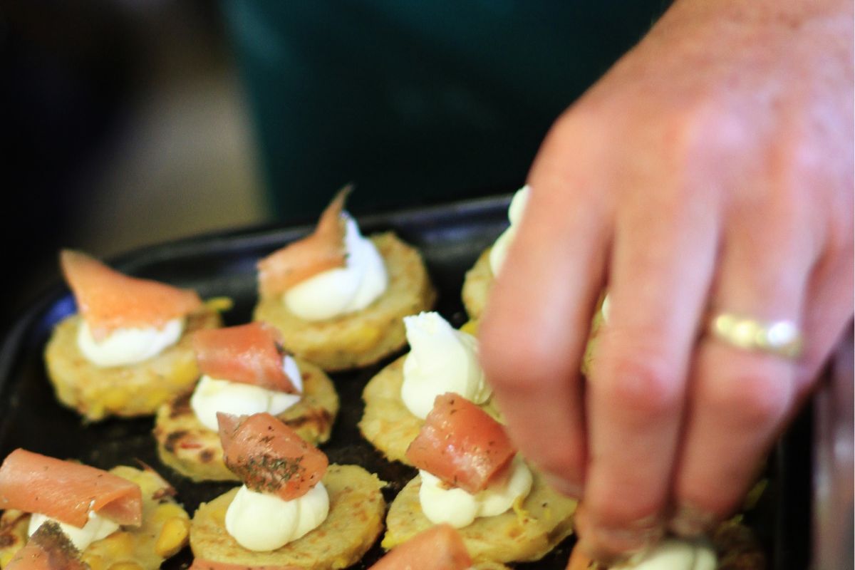 The picture shows a woman's hand prepping snacks at home.