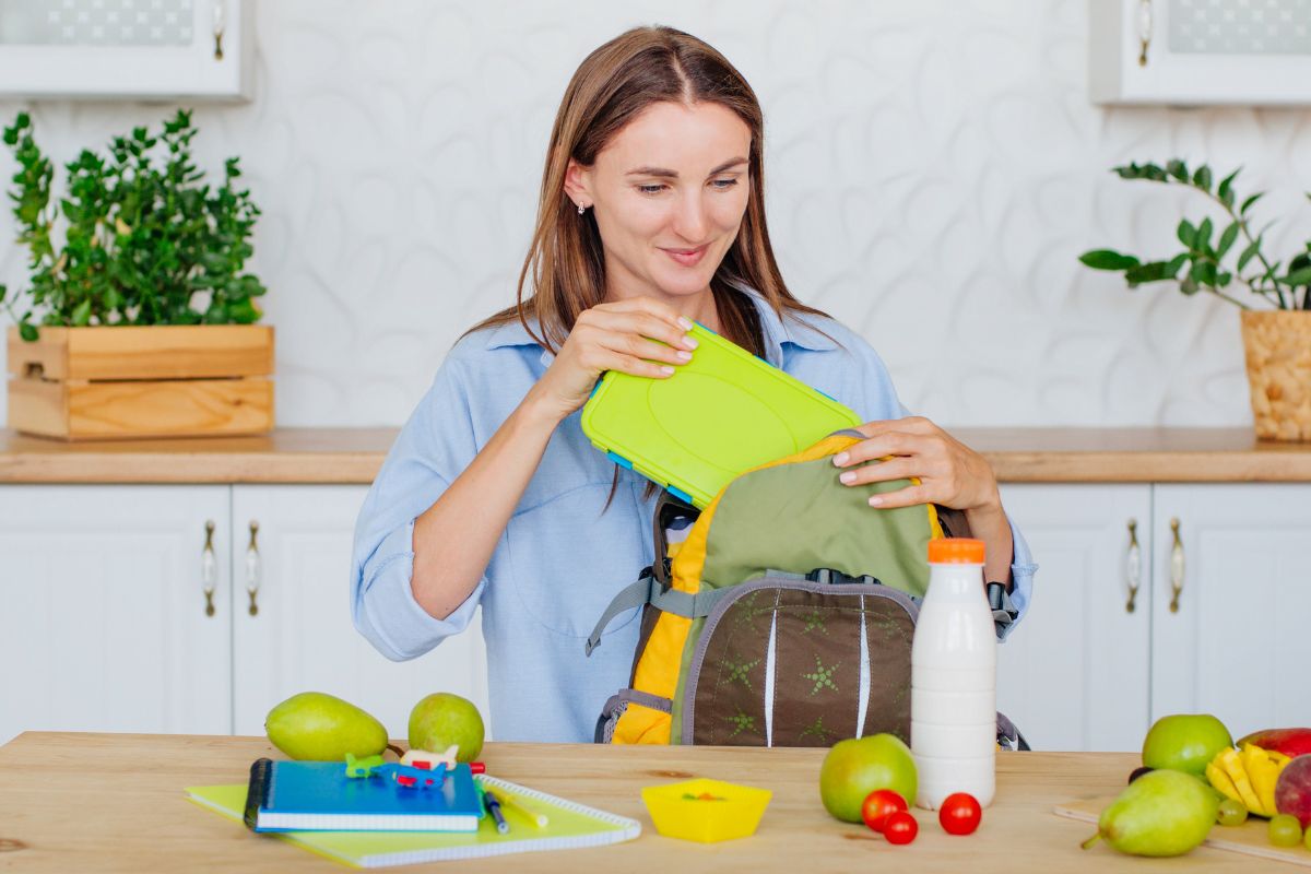 The photo shows a woman packing snacks in her bag.