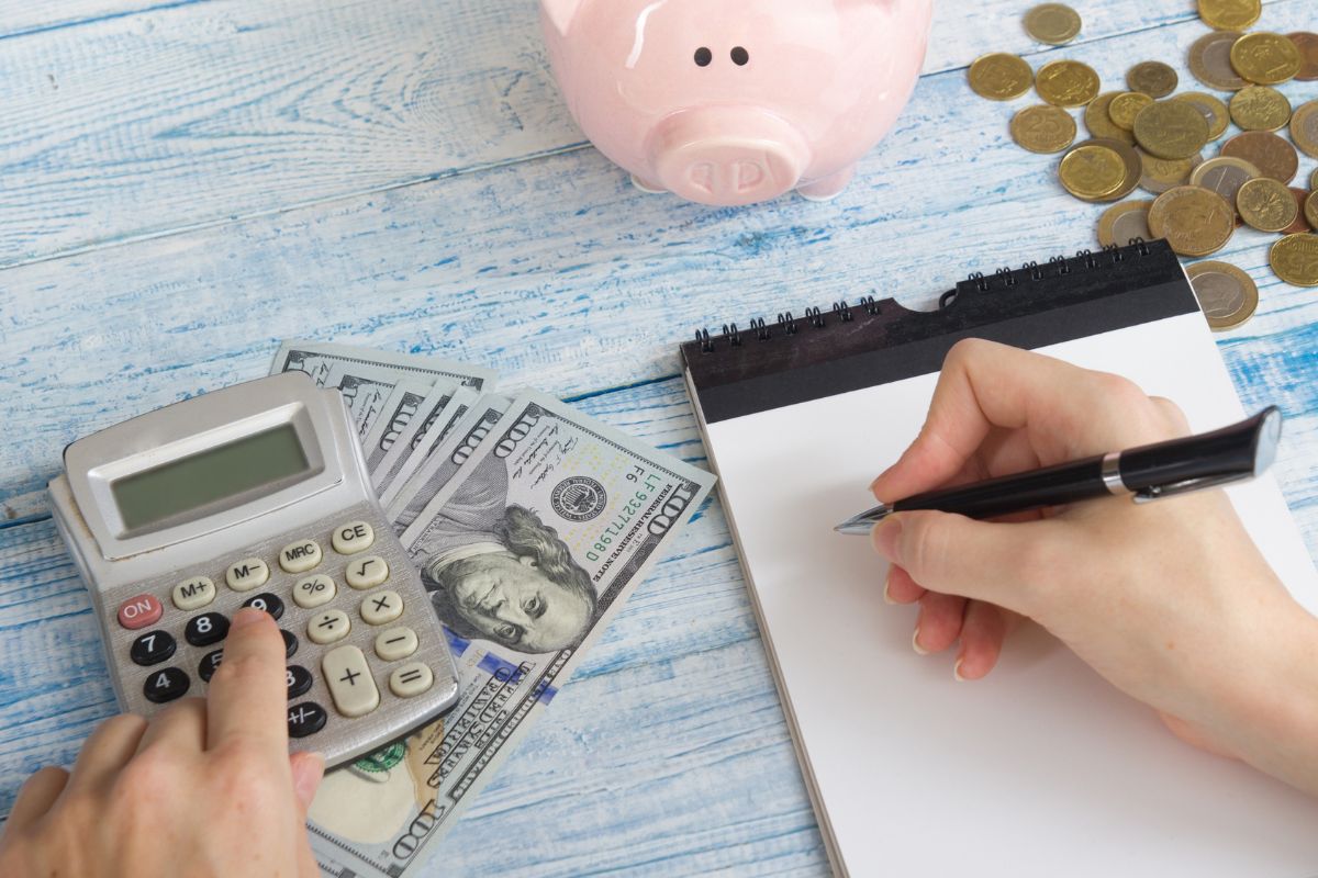 The photo shows a woman's hand making a food budget.