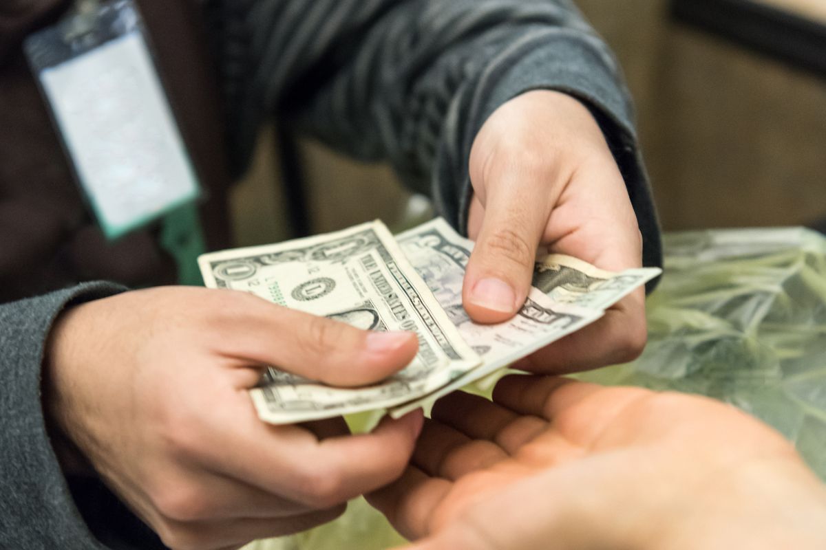 A picture of someone paying cash. 