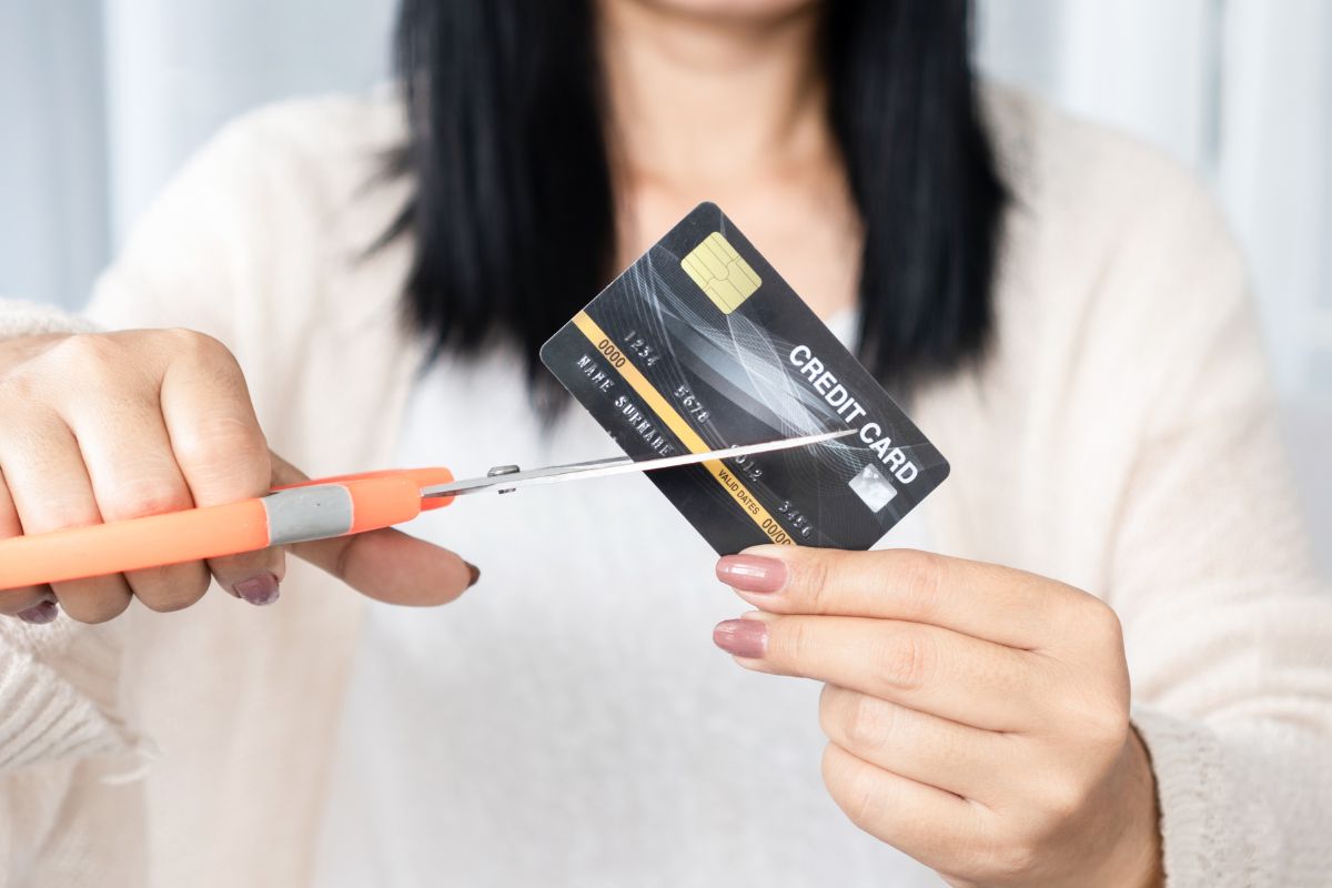 A picture of someone cutting their credit card. 
