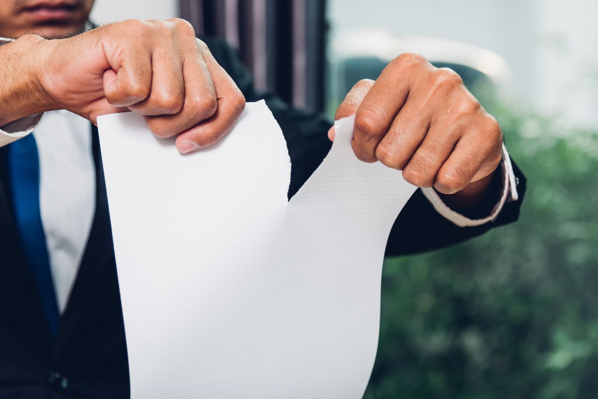 A picture of someone tearing a paper apart. 