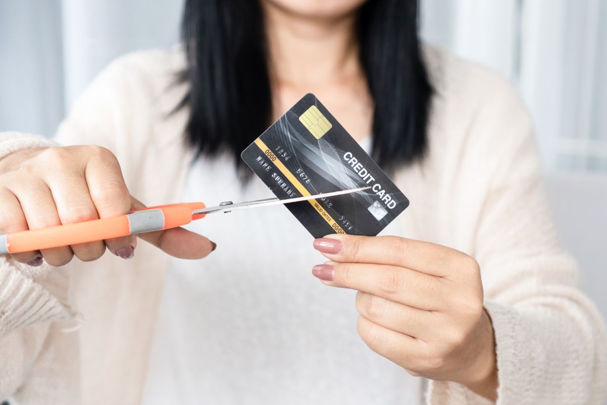 A picture of someone cutting their credit card. 