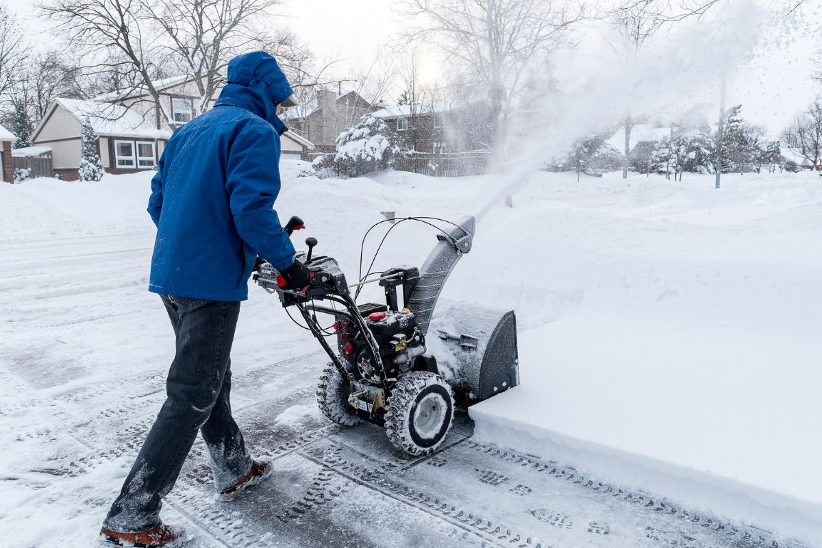 A picture of someone doing snow removal using a machine. 