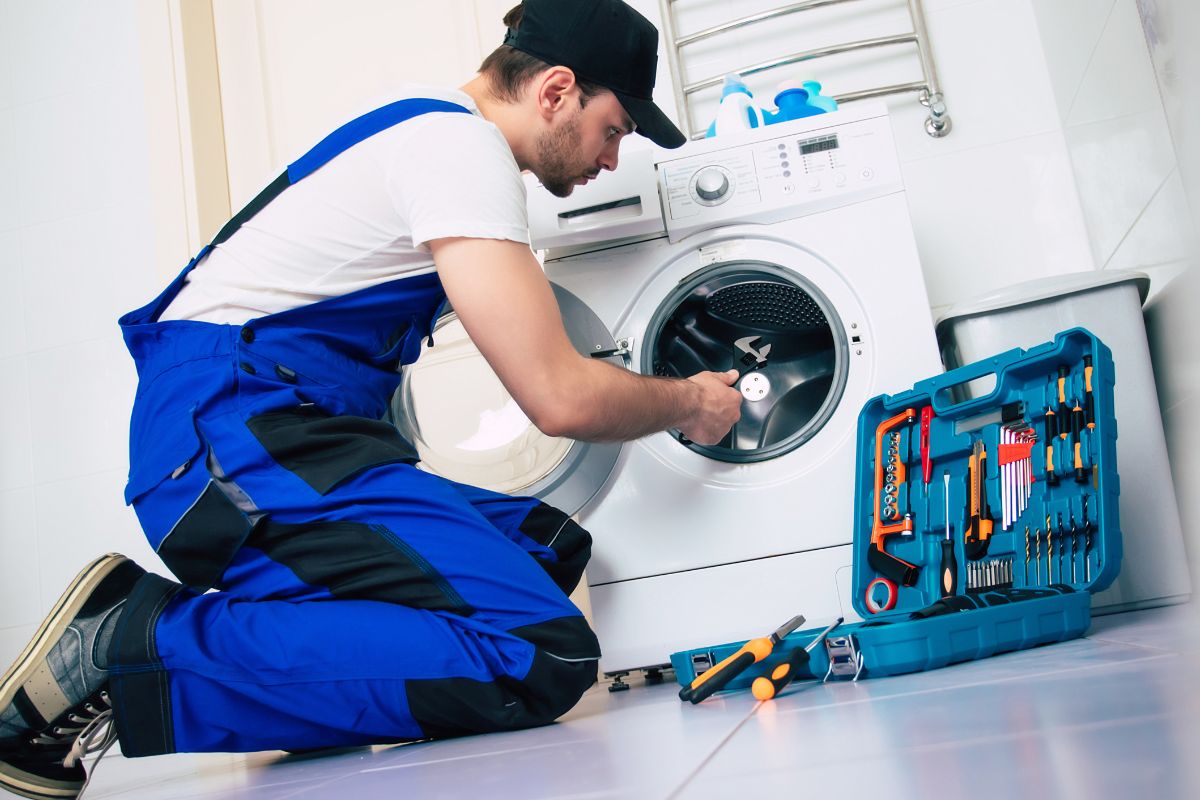 A picture of someone repairing a washing machine. 