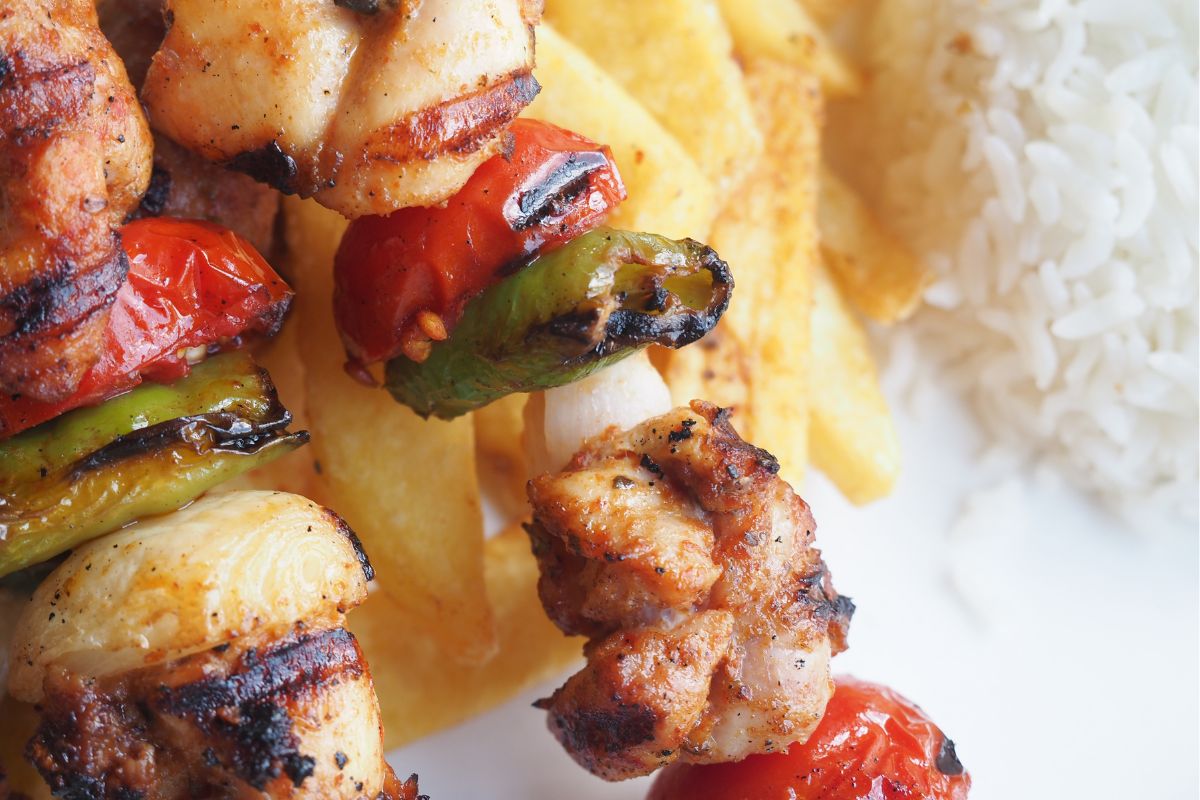 A picture of Grilled chicken skewers with rice.