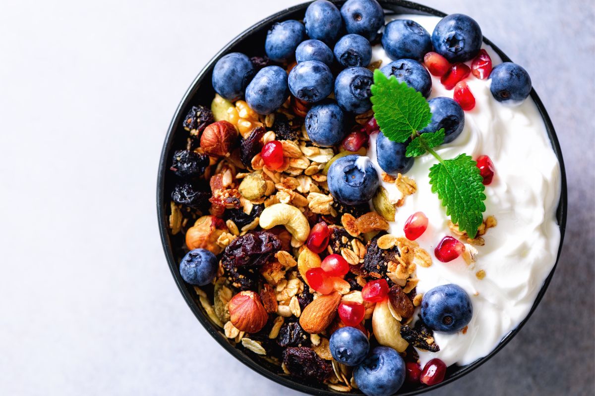 A picture of Greek yogurt with fruit and granola.
