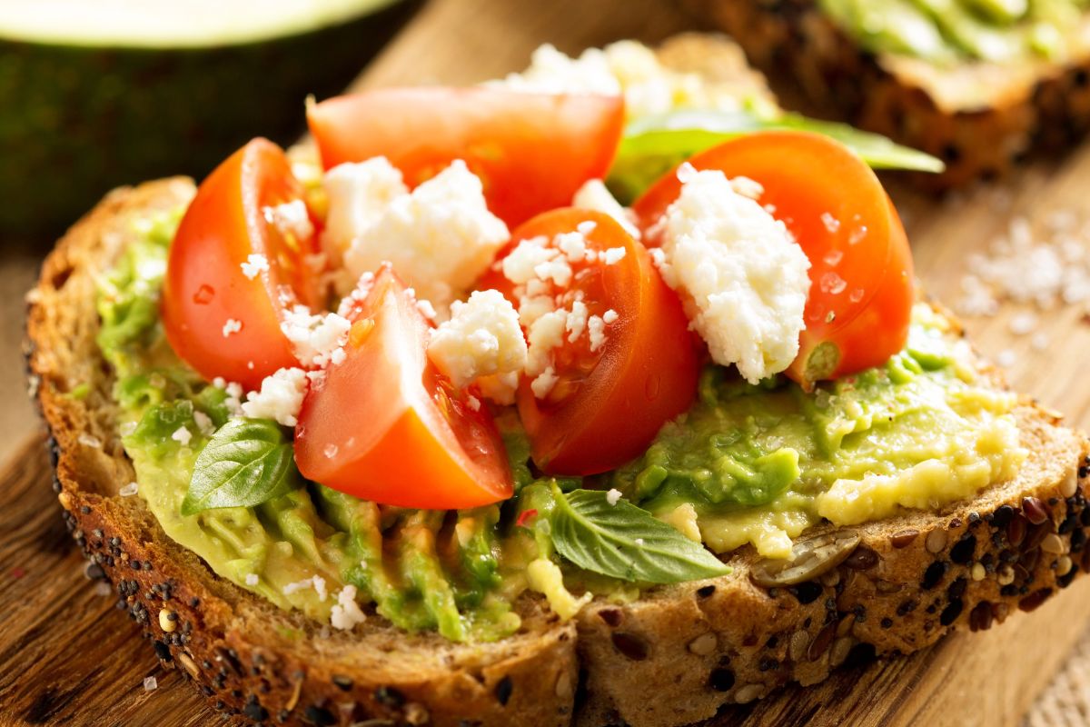 A picture of Avocado toast with tomato slices.