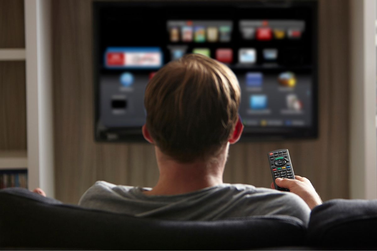 A picture of someone using his television. 