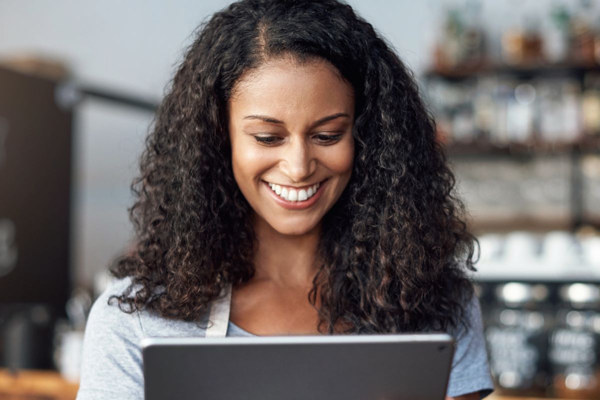 A picture of someone smiling while looking at her gadget. 