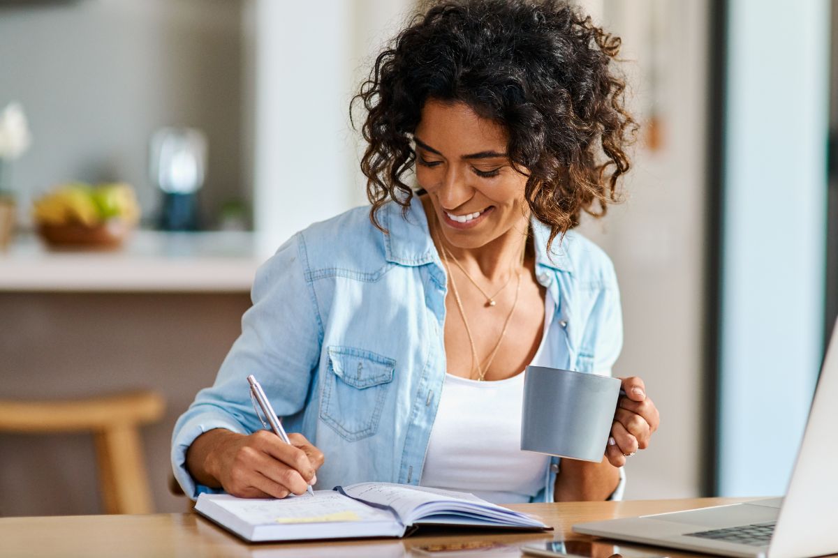 A picture of someone smiling while writing something. 