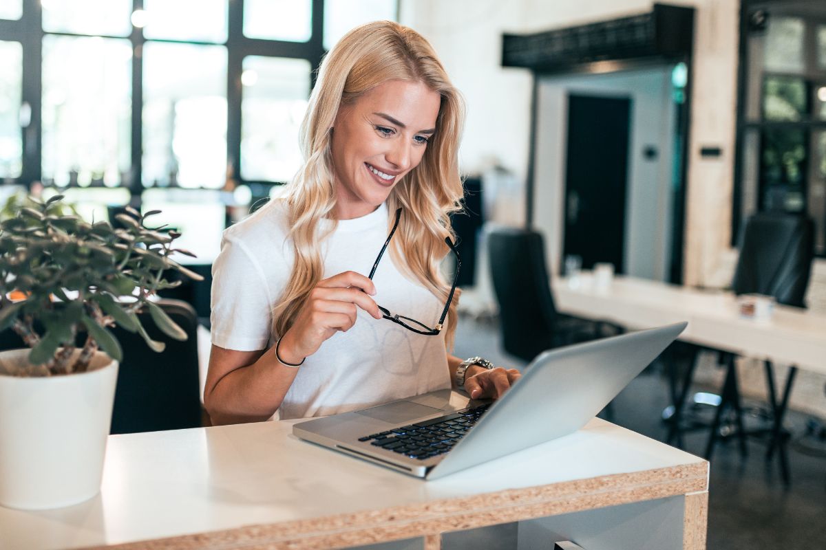 A picture of smiling while looking at her laptop. 
