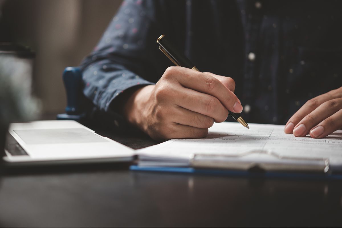 A picture of someone writing something down. 
