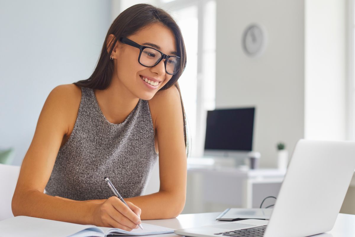 A picture of someone smiling while writing something. 