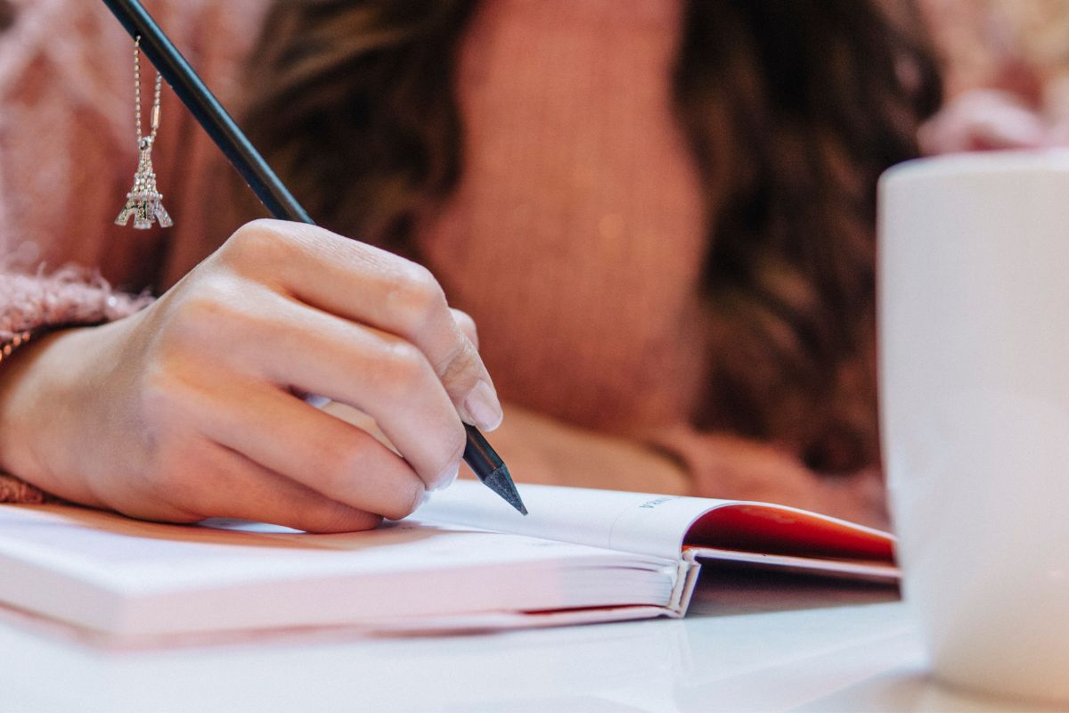A picture of someone writing something down. 