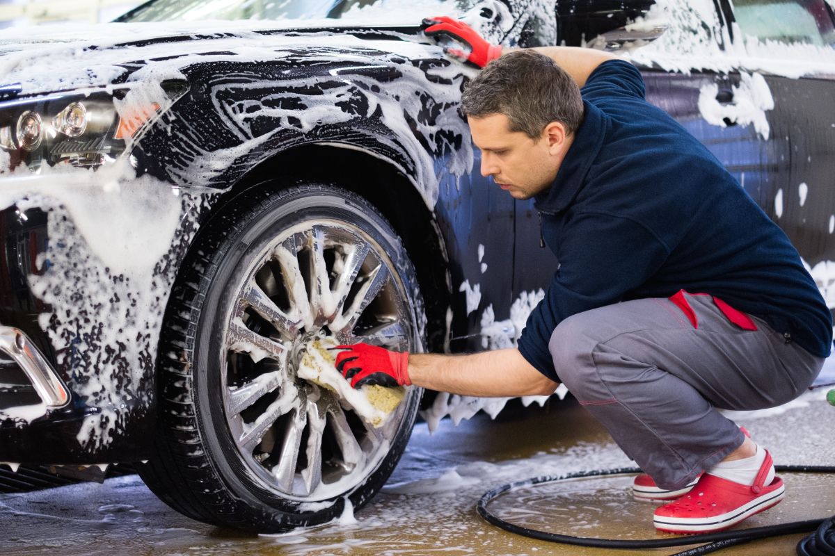 A picture of someone cleaning a car.