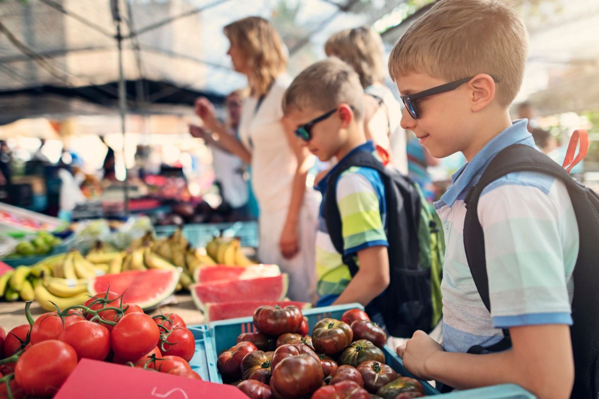 A picture of children in a farmer's market. 