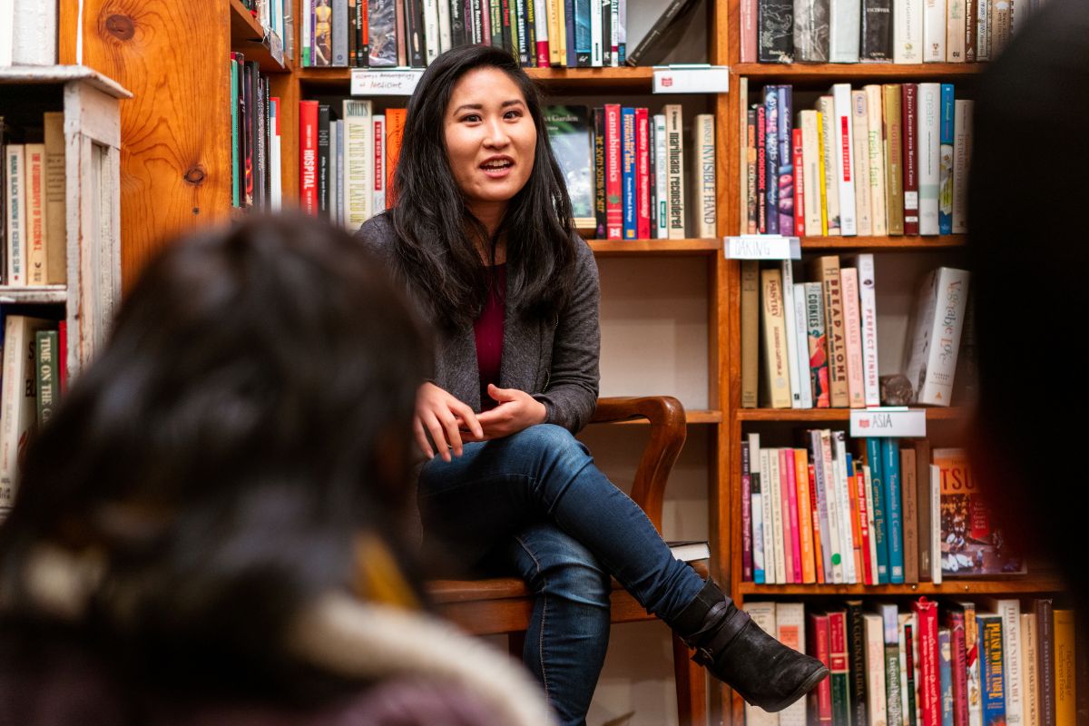A picture of someone talking to kids in a bookstore. 