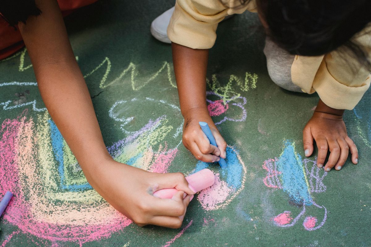 A picture of someone doing sidewalk chalk art. 