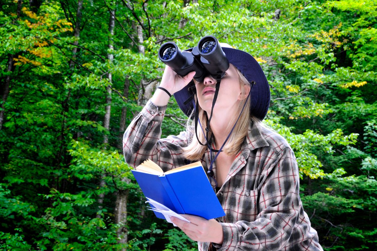 A picture of a bird watcher and her notebook. 