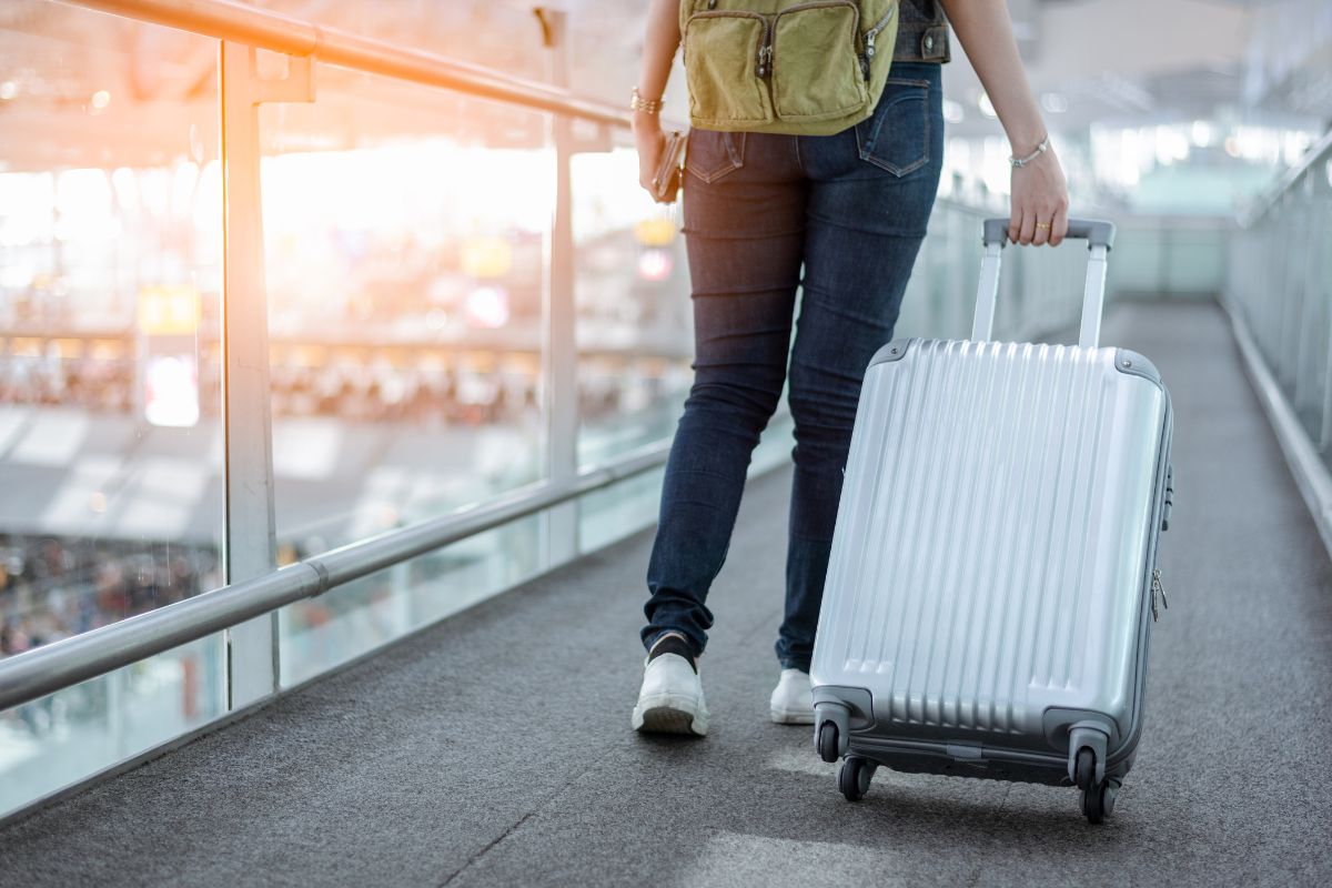 A picture of someone pulling her luggage.