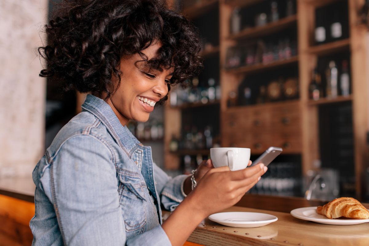 A picture of a woman smiling at her phone. 