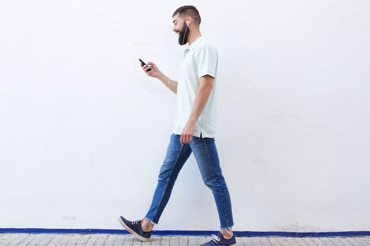 A picture of man looking at phone happily. 