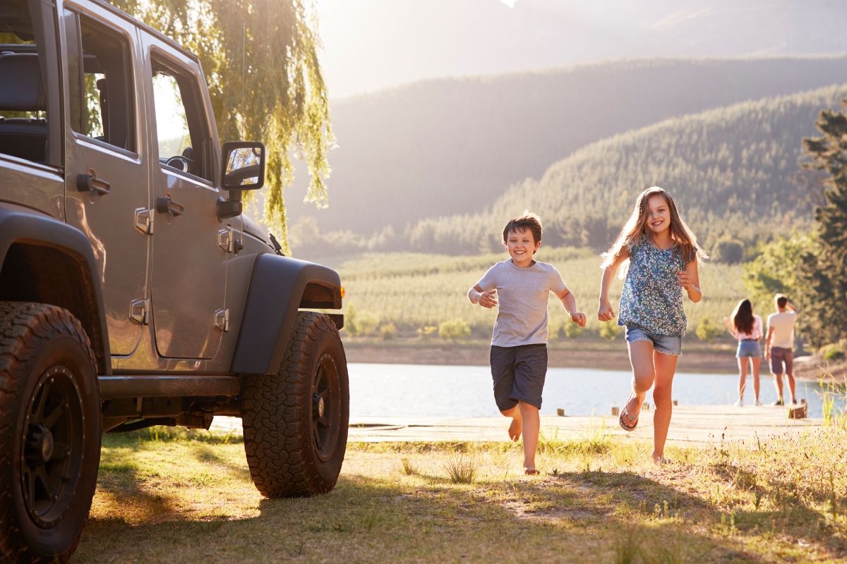 A picture of children running to the car. 