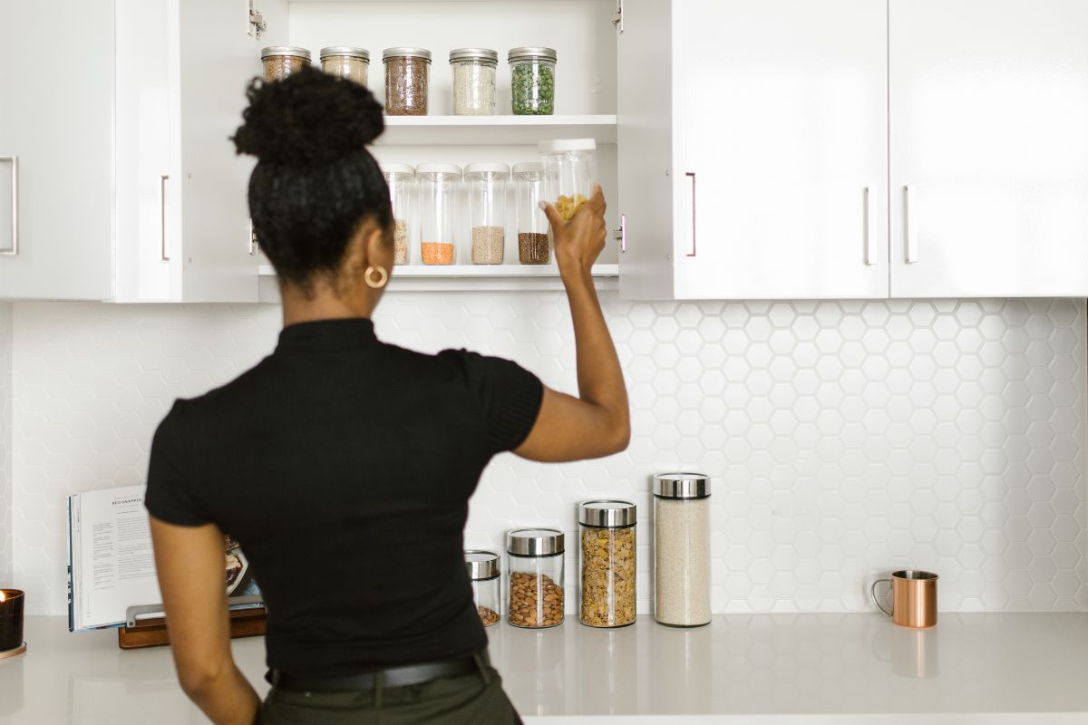 A picture of someone looking at her pantry. 