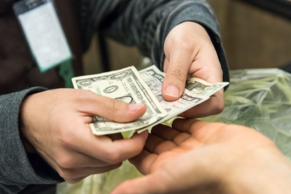 A picture of someone paying in cash.