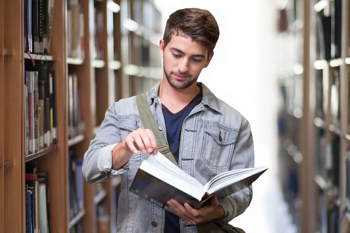 Image of a man reading something from the library.