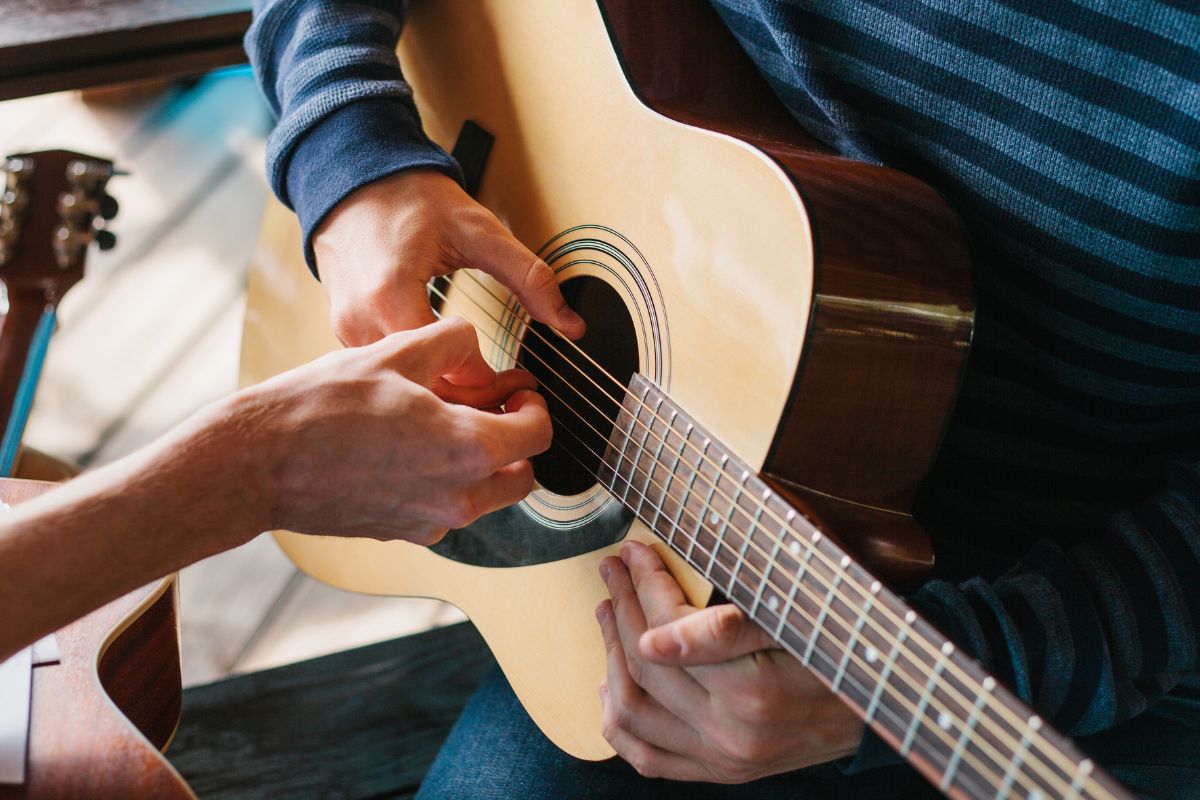 Image of someone learning to play the guitar.