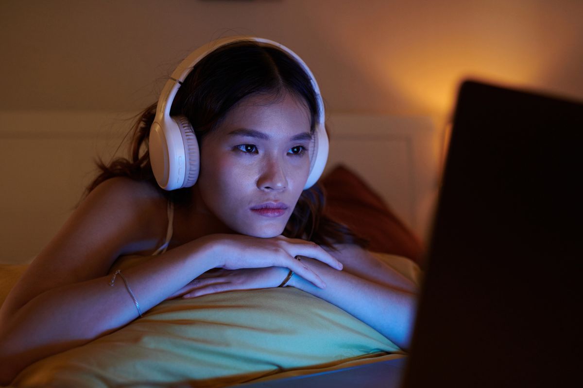 Image of a lady watching something in her laptop. 