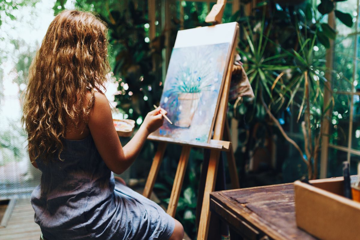 Picture of a lady painting a plant. 