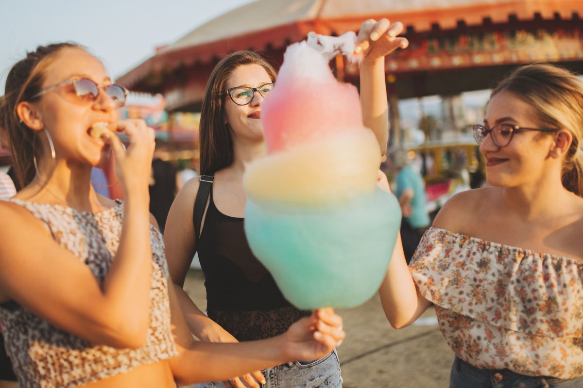 Picture of friends eating cotton candy at the fair. 